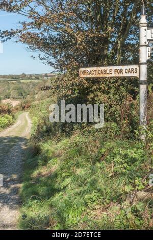 Altes Straßenschild im ländlichen Stil mit Schild "undurchführbar für Autos" in der Nähe von St. Winnow, Cornwall. Landstraße nicht geeignet für Autos, Offroad, unebene Strecke. Stockfoto