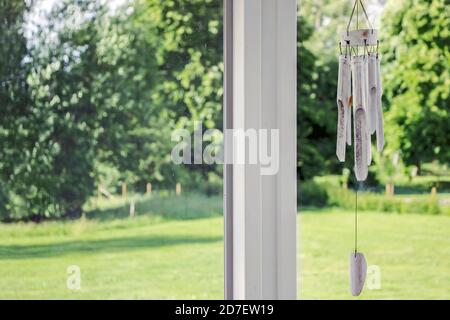 Weißes Holzspiel auf dem Balkon mit grünen Pflanzen Stockfoto