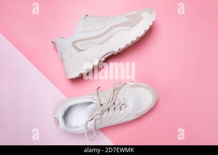 Beige Damen Sneaker auf rosa Hintergrund. Stockfoto