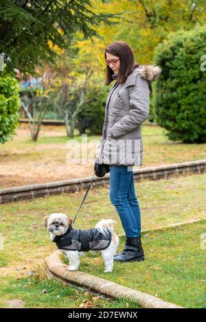 Frau, die im Park mit ihrem Hund in der Regen Stockfoto