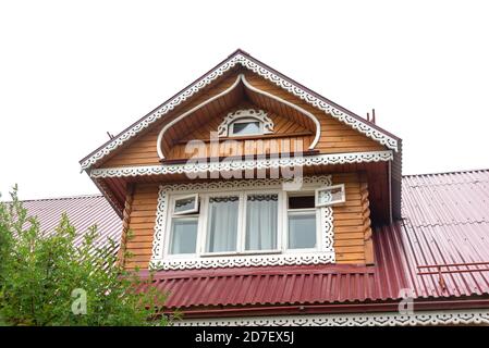 Mansarde mit großem Fenster auf rotem Dach des Landhauses Stockfoto