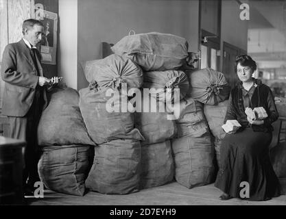 Sup. Marvin McLean und Mrs. Clara R.A. Nelson mit Taschen von Dead Letter Mail, U.S. Post Office, Washington, D.C., USA, Harris & Ewing, Oktober 1916 Stockfoto