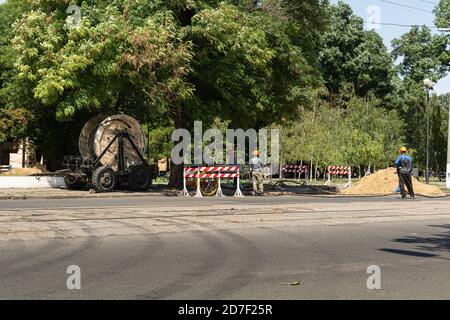 Odessa, Ukraine - 8. August 2019: Arbeiter ziehen eine Rolle Hochspannungskabel Stockfoto