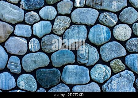 Handgemachte Wandoberfläche. Hintergrund von großen abgerundeten grauen Steinen, Kieselsteine, Kopierraum Stockfoto