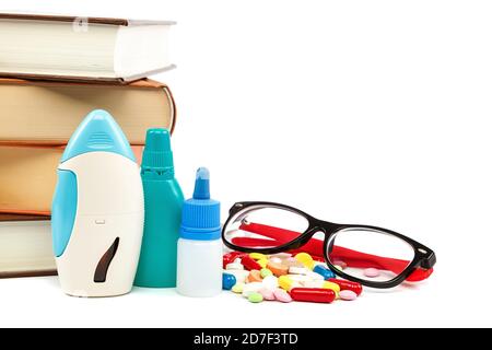 Stapel von Büchern und Pillen, Kapseln isoliert auf weißem Hintergrund. Arzneimittel. Medikamente und Medikamente. Stockfoto