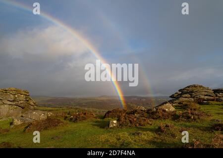 Dartmoor National Park, Devon, Großbritannien. Oktober 2020. UK Wetter: Ein doppelter Regenbogen erscheint am Himmel über den Emsworthy Felsen in der Nähe von Holwell Tor am Dartmoor nach heftigen Regenschauern und sonnigen Zaubersprüchen, die ein deutlich herbstliches Gefühl in den Tag bringen. Kredit: Celia McMahon/Alamy Live Nachrichten Stockfoto