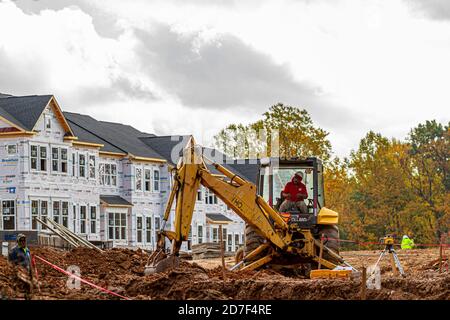 Clarksburg, MD, USA 10/21/2020: Aus einem ehemaligen Wald wird ein Wohngebiet in einem Vorort. Ein Mann arbeitet Bagger Stockfoto