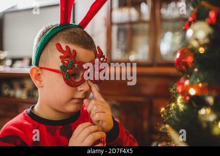 Kaukasischen Jungen Dekoration Weihnachtsbaum zu Hause Stockfoto