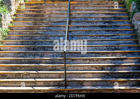 Verwitterte Betontreppe mit einem Metallgriff in der Mitte Stockfoto