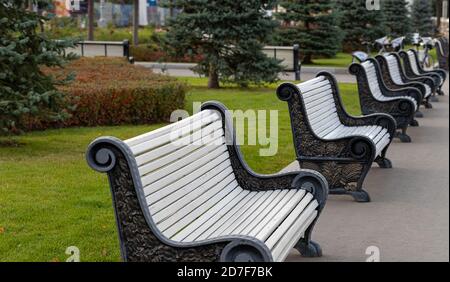 Perspektive von leeren weißen Bänken in einer Reihe an der Öffentlichkeit parkallee Stockfoto