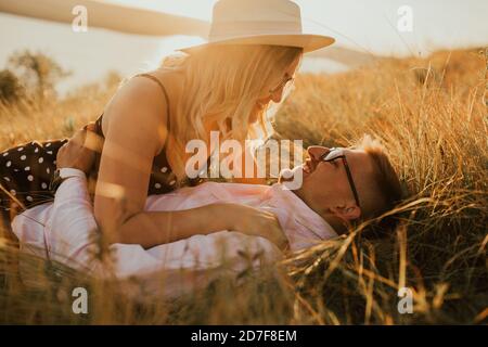 Mann und Frau im Hut liegen auf dem Rasen Stockfoto