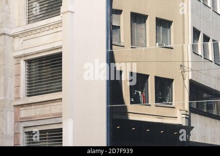 Abstraktes Fragment der alten Gebäudearchitektur, das sich im modernen Firmengebäude widerspiegelt. Vorderansicht des Gebäudes. Mailand, Italien Stockfoto