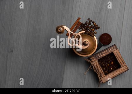 Manuelle Vintage Kaffeemühle mit Kaffeebohnen in der Box und Zimtstangen auf Holzoberfläche. Speicherplatz kopieren Stockfoto