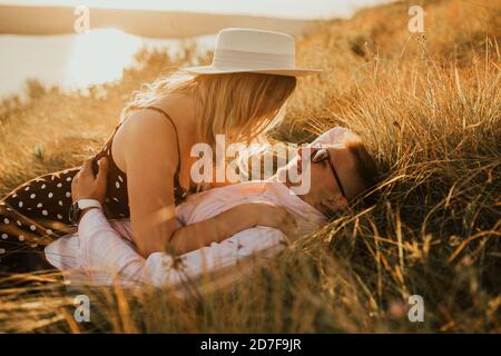 Mann und Frau im Hut liegen auf dem Rasen Stockfoto