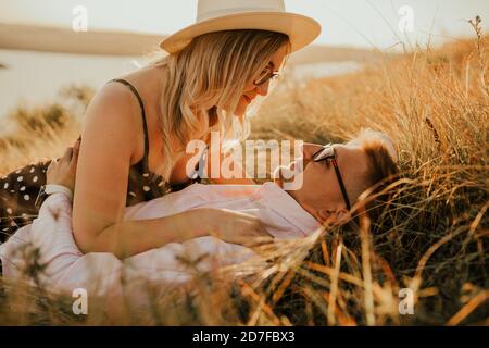 Mann und Frau im Hut liegen auf dem Rasen Stockfoto