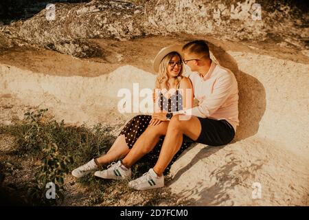 Mann und Frau im Hut sitzen auf einem großen Stein Rock Stockfoto