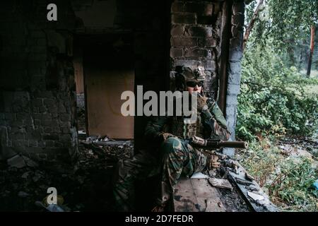 Soldat im Gespräch auf dem Walkie-Talkie im Gebäude, militärische Konzept Stockfoto
