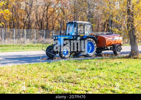 Samara, Russland - 4. Oktober 2020: Moderner Radtraktor Belarus mit einem Fass für Wasser auf der Asphaltstraße Stockfoto