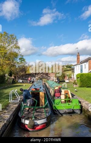 Traditionelle, schmale Boote und Lastkähne, die auf dem Grand Union Canal in Braunston in northamptonshire, großbritannien, in eine Schleuse fahren Stockfoto