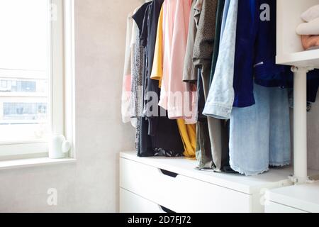 Bunte Sammlung von Frauenkleidung hängt auf einem Regal, moderne Casual Schrank in hellen Raum, moderne Ankleidezimmer Stockfoto