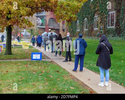 Oak Park, Illinois, USA. Oktober 2020. Frühe Wähler ertragen das feuchte Wetter und wartet bis zu eineinhalb Stunden, um heute in diesem westlichen Vorort von Chicago im Dorfhaus abzustimmen. Stockfoto