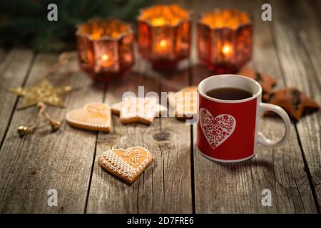 Hausgemachter Weihnachts-Glühwein-Punsch mit Lebkuchen auf Holz-rustikalen Tisch. Brennende Kerzen im Hintergrund. Traditionelles warmes Getränk im Herbst und Winter. Stockfoto