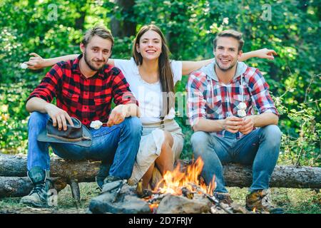 Picknickzeit. Friends Camping Konzept. Touristen entspannen. Betriebsfreunde genießen es, gemeinsam im Wald zu entspannen. Sie sitzen um Lagerfeuer herum. Glücklich Stockfoto