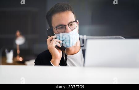Rezeptionist Mann An Der Rezeption Trägt Gesichtsmaske Stockfoto