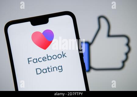 Manchester / Vereinigtes Königreich - 21. Oktober 2020: Facebook Dating App Logo auf dem Smartphone-Bildschirm neben groß wie auf dem verschwommenen Hintergrund gesehen. Stockfoto