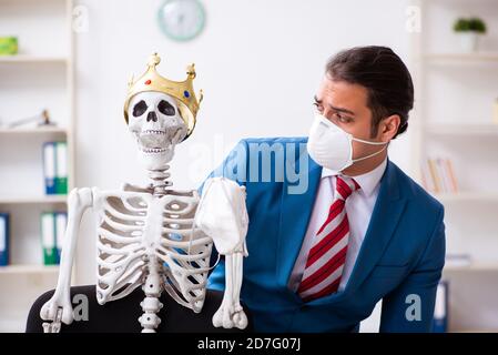 Geschäftsmann und Skelett im Büro in Pandemiekonzept Stockfoto