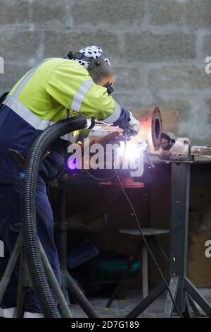 Nahaufnahme von mans Händen arbeiten mit einem kreisförmigen Schleifstein Stockfoto