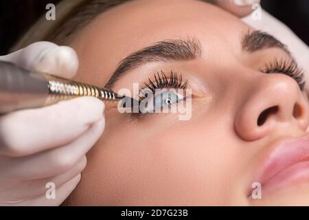 Dauerhafte Augen Make-up Nahaufnahme. Kosmetologe Anwendung Tätowierung der Augen. Make-up Eyeliner Verfahren Stockfoto