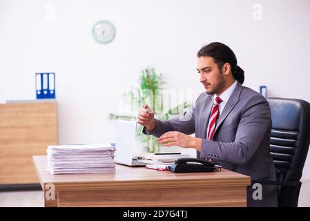 Männlicher Mitarbeiter, der Flash-Laufwerk in den Laptop einsteckt Stockfoto