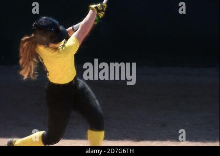 Eine weibliche Baseball-Spielerin Schwingt Ihren Bat für die Zäune Im Turnierspiel. Stockfoto