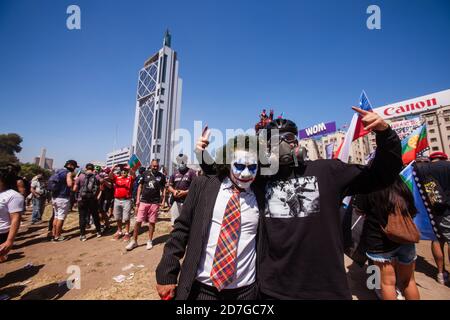 SANTIAGO, CHILE-18. OKTOBER 2020 - die Demonstranten werden mit einem als Joker gekleideten Mann am ersten Jahrestag des sozialen Ausbruchs im Oktober fotografiert Stockfoto
