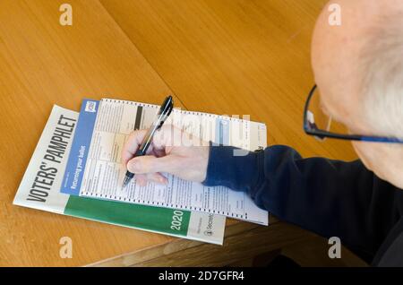 Ein Wähler füllt einen Stimmzettel zu Hause aus, der vor dem Wahltag, dem 3. November 2020, eingesendet werden soll. Stockfoto