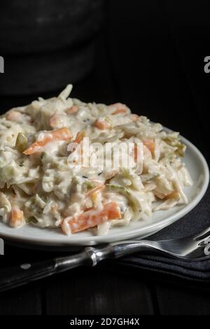 Koleslaw. Salat aus geschreddertem Weißkohl und geriebener Karotte mit Mayonnaise auf dem Teller. Stockfoto