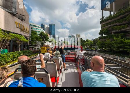 Singapur - 4. Dezember 2019: Die Menschen sehen sich die Sehenswürdigkeiten von Singapur mit dem Hop-on-Hop-off-Bus an - gehen Sie entlang der Tong Sen Straße in Singapur. Stockfoto