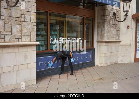 Während einer Pandemie-Herbstsaison reinigt ein Arbeiter die Schaufensterflächen eines Bluemercury-Parfümerieladens im Einkaufszentrum Bridgeport Village in Tigard, Oregon. Stockfoto