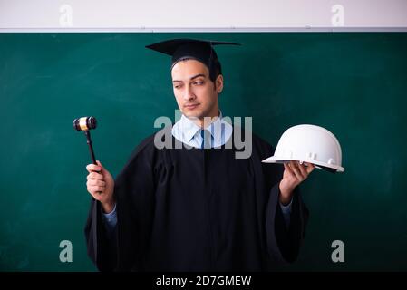 Junger männlicher Absolvent vor dem Vorstand Stockfoto