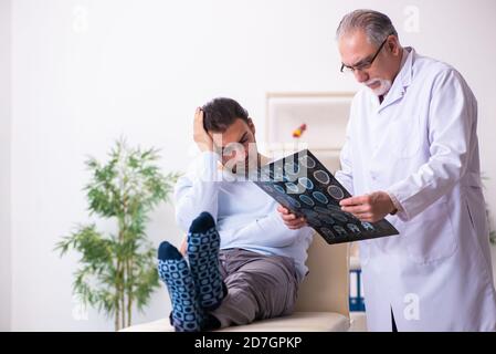 Kranker Mann besucht alten Arzt Radiologen Stockfoto