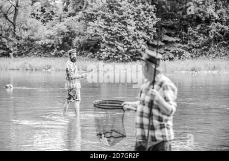 Fischer mit Angel. Aktivität und Hobby. Angeln Süßwasser-See, Teich, Fluss. Bärtige Männer, Fische zu fangen. Reifer Mann mit Freund angeln. Sommer Urlaub. Das Leben ist immer besser, wenn ich angeln. Stockfoto