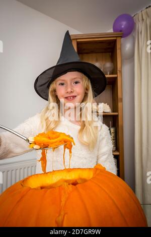 Junges Mädchen in Hexenhut Vorbereitung Kürbis, Essen, Spaß, halloween Stockfoto