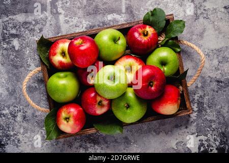 Reife rote und grüne Äpfel in Holzkiste.Draufsicht mit Kopierraum. Stockfoto