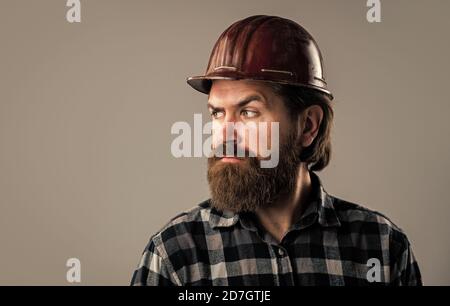 Selbstbewusster Mechaniker. Bärtiger Mechaniker. Selbstbewusster Bauingenieur. Professioneller Architekt. Reparatur oder Gebäude. Verantwortlich für die Sicherheit. Seriöser männlicher Arbeiter trägt einen Hut. Brutaler Baumeister im Helm. Stockfoto