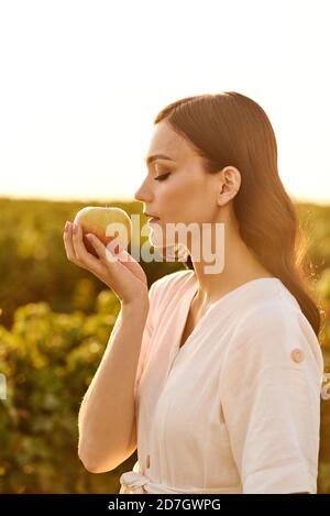 Mädchen mit Apfel in der Hand auf grünem Feld Hintergrund. Stockfoto