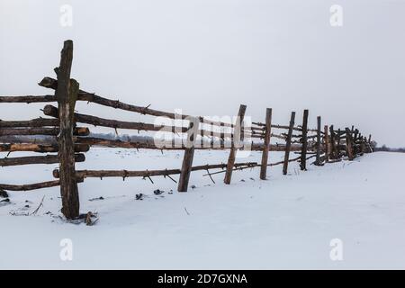 Winterlandschaft. Schneefeld mit einem Holzzaun. Stockfoto