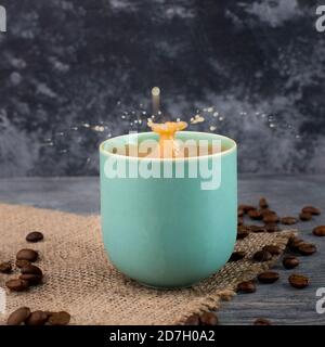 Tasse Kaffee mit gerösteten Bohnen, Spritzer, leerer Kopierraum Stockfoto