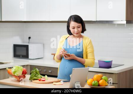 Frau, die eine Einkaufsliste über die Küche schrieb Stockfoto