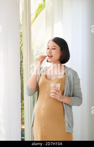 Junge schwangere Frau, die Kapsel Stockfoto